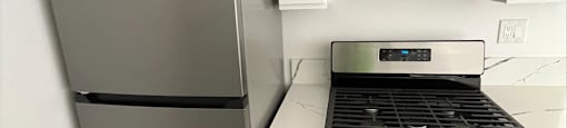 a kitchen with white cabinets and stainless steel appliances